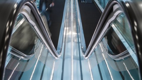 Close-up moving escalator handrail shot in time lapse. Unrecognizable people with bags and suitcases go up and down in airport or train station, fast motion