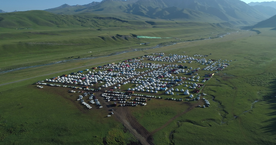 top view of many cars and withe rounded tents setting and camping together in the huge prairie along the stream in xinjiang, china