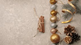 New Year and Christmas decoration. Some pine cones, branches of Christmas tree, cinnamon sticks, ribbons and flowers on a silver texture. Hand puts a cup with Christmas tea on the table. Top view - Powered by Shutterstock - Get 15% off with code: PIKWIZARD15