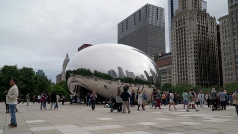 Chicago, USA - Circa 2019: Timelapse day time exterior establishing shot famous cloud gate art sculpture in downtown park made of steel reflecting cityscape skyline on Chicago bean people visit park