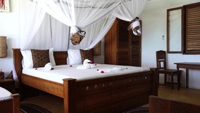 Interior design decor furnishing of luxury show home holiday villa bedroom with four poster bed. Interior design of the tropical villa on sea, island of Zanzibar, Tanzania, Africa, establishing shot - Powered by Shutterstock - Get 15% off with code: PIKWIZARD15