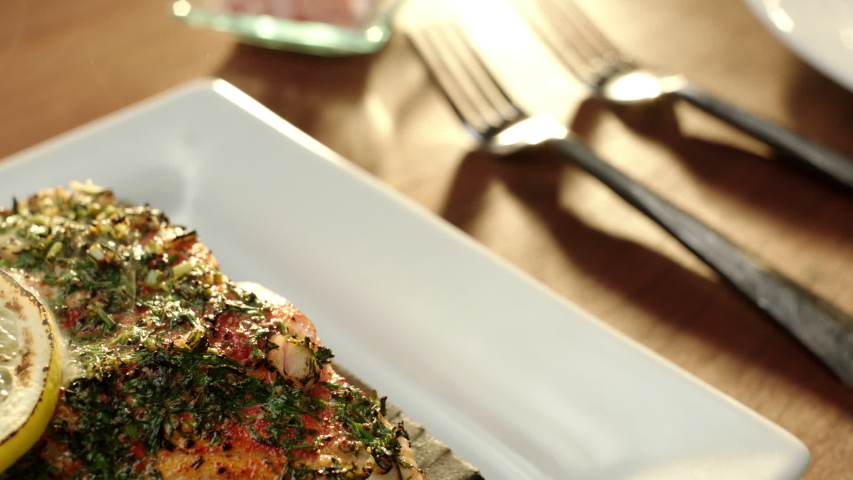 Salmon fillet cedar planked presented on platter with dill and lemon garnishing
