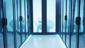 In data center, computer spy hiding behind door, programming spyware programs on laptop trying to steal information and brea server. Walkthrough shot of empty server room. - Powered by Shutterstock - Get 15% off with code: PIKWIZARD15