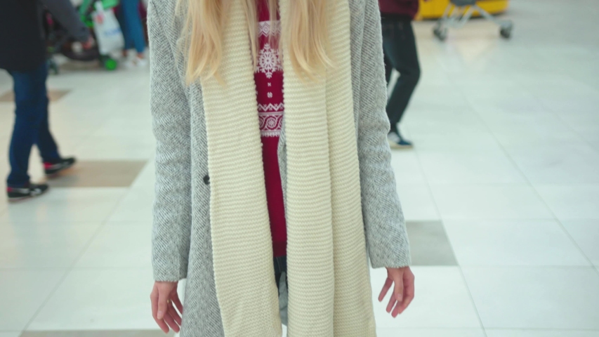 Close up young beautiful woman wear hat shrug shoulders Christmas presents boxes fall on the ground in shopping mall sad buy new year holiday portrait close up slow motion