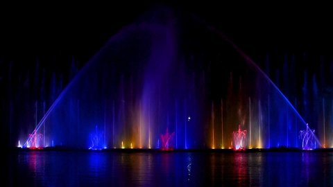 Musical fountain with laser animations. Evening show Roshen fountain. Night laser fountain show, on the Roshen embankment, the Ukrainian city of Vinnitsa.Musical fountain "Roshen" in Vinnitsa, Ukraine