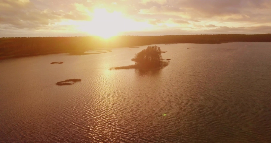 Lake sunset view with islands, aerial flight over the lake