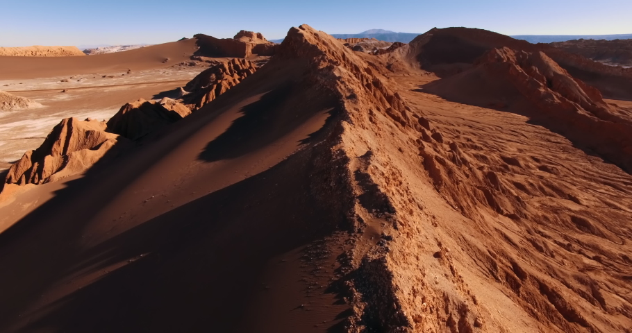 The flight over the dune ridge in Moon Valley. Fantastic landscape of Atacama desert. Panoramic view of vast arid terrain and erosion formations. San Pedro de Atacama. Chile. Aerial. 4K Royalty-Free Stock Footage #1042094503