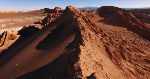 The flight over the dune ridge in Moon Valley. Fantastic landscape of Atacama desert. Panoramic view of vast arid terrain and erosion formations. San Pedro de Atacama. Chile. Aerial. 4K