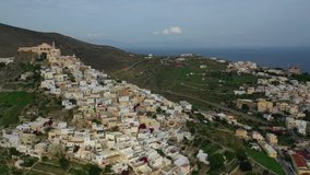 Aerial drone video of iconic uphill catholic settlement of ano Syra featuring church of Saint George at sunset with beautiful colours, Syros or Siros island, Cyclades, Greece