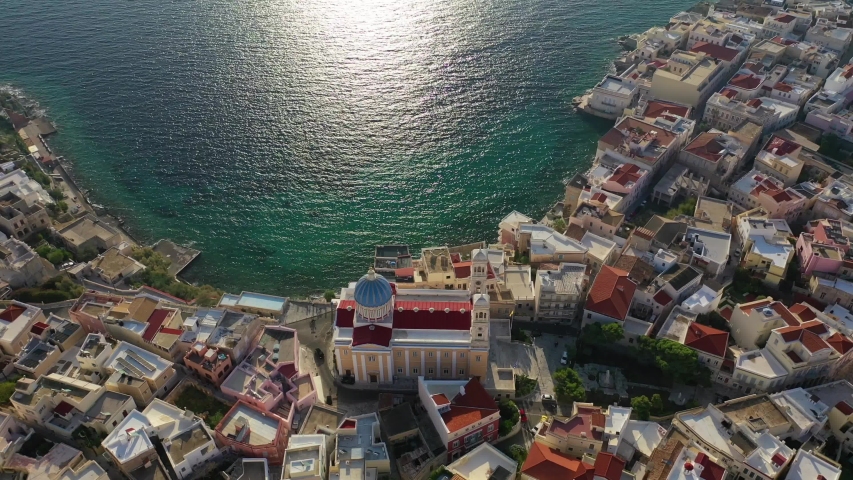 Aerial drone video of picturesque district built by the sea of Vaporia in main town of Syros or Siros island Ermoupolis and famous church of Agios Nikolaos, Cyclades, Greece