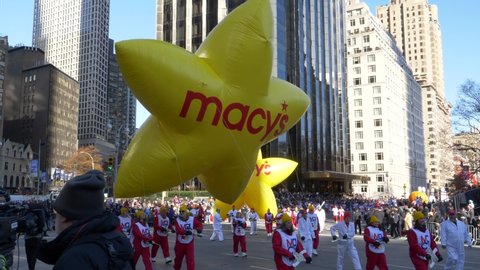 New York City, NY - November 28, 2019: Macy's Yellow Stars floating in to Columbus Circle in the Annual Macy's Thanksgiving Day Parade with masses of spectators