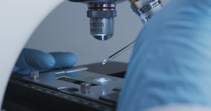 Crop shot of technician drips a solution from pipette on the glass slide for further examination under of microscope. - Powered by Shutterstock - Get 15% off with code: PIKWIZARD15