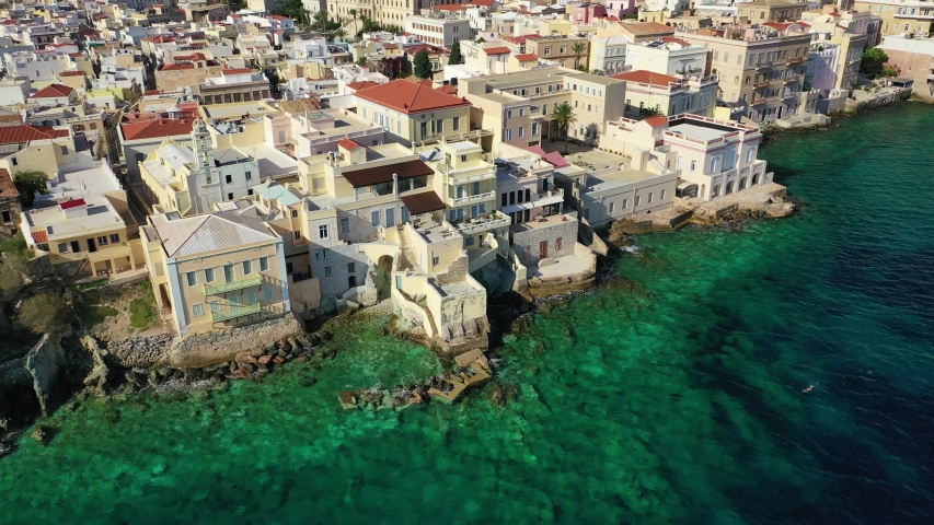 Aerial drone video of picturesque neoclassical houses district built by the sea of Vaporia in main town of Syros or Siros island Ermoupolis near famous church of Agios Nikolaos, Cyclades, Greece
