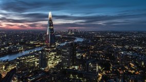 Establishing Aerial View of London, City Skyline, Shard and Tower Bridge in foreground, Canary Wharf in background, United Kingdom evening dusk night beautiful sky