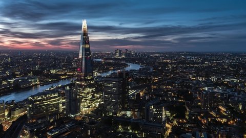 Establishing Aerial View of London, City Skyline, Shard and Tower Bridge in foreground, Canary Wharf in background, United Kingdom evening dusk night beautiful sky