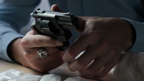 A gun in male hands, close-up. Man prepares a gun