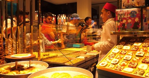 Istanbul,Turkey - October 2019: People buying souvenir in turkish confectionery Families buying Baklava Kunefe pastries in fancy sweet shop Istiklal avenue