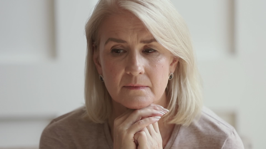 Head shot close up unhappy middle aged woman lost in thoughts. Upset older female pensioner thinking of bad diagnosis, feeling lonely or unsafe. Frustrated mature grandmother worrying about problems. | Shutterstock HD Video #1042130734
