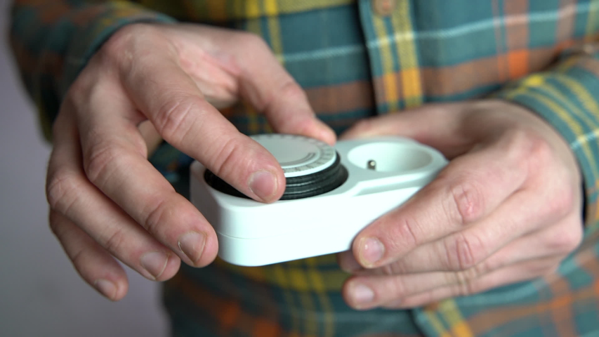 Man setting up plug-in timer switch