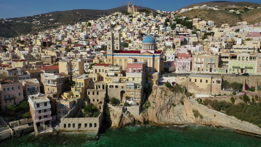 Aerial drone video of picturesque district built by the sea of Vaporia in main town of Syros or Siros island Ermoupolis near famous church of Agios Nikolaos, Cyclades, Greece