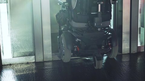 4k resolution of a disabled man on a electric wheelchair going in the elevator