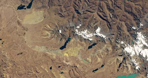 Very high-altitude overflight aerial of La Rinconada, Peru's eastern Andes mountains. Clip loops and is reversible. Elements of this image furnished by NASA