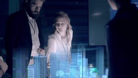 In the Near Future: Businessman in Suit presenting Architectural Project to Colleagues and Partners Standing around Futuristic Table with Holographic Modern Augmented Reality Technology. - Powered by Shutterstock - Get 15% off with code: PIKWIZARD15