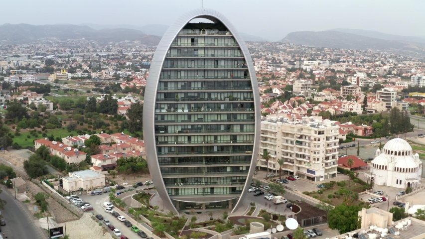 Limassol, Cyprus - November 2019 : Modern business center with offices in shape of oval or egg in Limassol downtown near embankment, aerial view from drone
