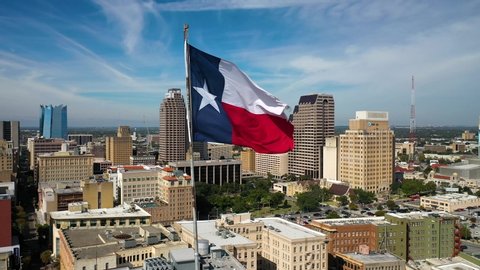 4K Slow Drone Orbit of Texas State Flag with San Antonio Skyline in Background