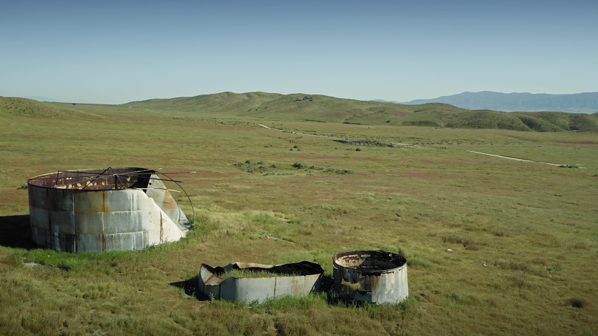 Aerial: abandoned grain silos and water tanks on deserted farm. Carrizo Plain National Monument, California, USA 