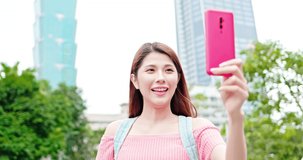 asian girl use smart phone to live stream outdoor when she is traveling - location taipei and taiwan