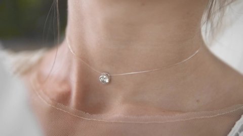Bride pearl diamond precious locket necklace locked on wedding day, closeup
