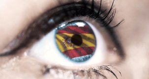 woman blue eye in close up with the flag of spain in iris with wind motion. video concept
