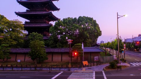 Kyoto, Japan. Car traffic in the morning in front of Toji Temple in Kyoto, Japan. Time-lapse with clear sky and cars in the sunrise, panning video