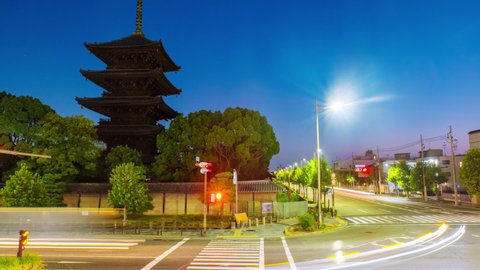 Kyoto, Japan. Car traffic in the morning in front of Toji Temple in Kyoto, Japan. Time-lapse with clear sky and cars in the sunrise, zoom in