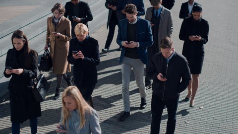 Multicultural Diverse Office Managers and Business People Commute to Work in the Morning or from Office on a Sunny Day on Foot. Pedestrians are Dressed Smartly. Successful People Holding Smartphones.