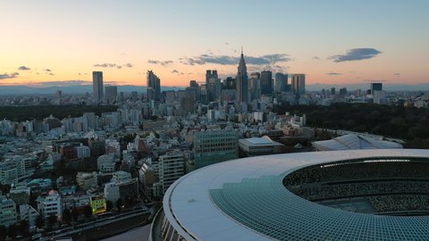 TOKYO, JAPAN - END OF 2019: Aerial view of New National Stadium, completed main stadium for Olympic Summer Games 2021 (originally 2020), skyscrapers skyline of modern district Shinjuku in background.