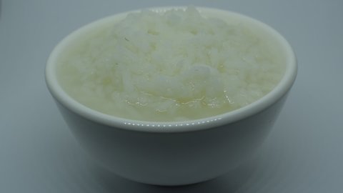 boiled rice in cup on white background