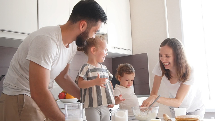 Adorable family cooking together in the kitchen with modern interior. Royalty-Free Stock Footage #1042207087