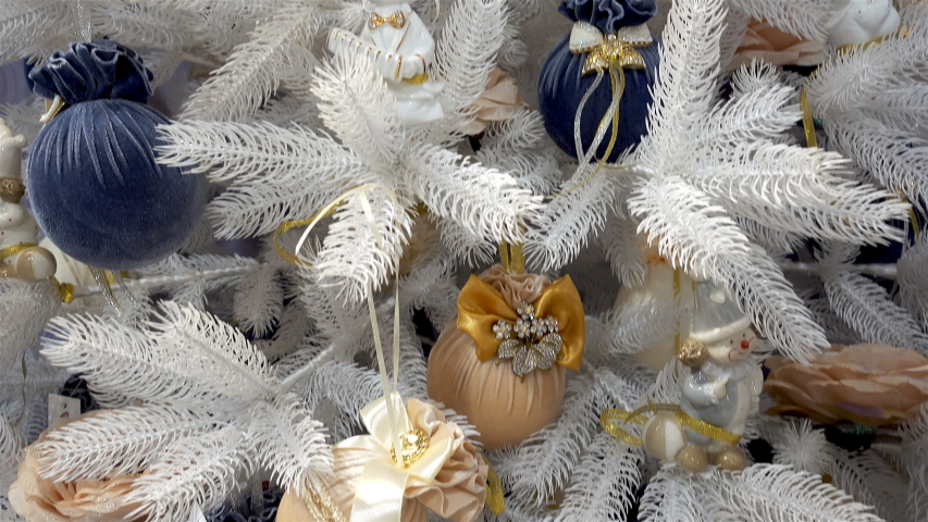 White christmas tree decorated with beautiful balls with bows and other toys in 4K.	