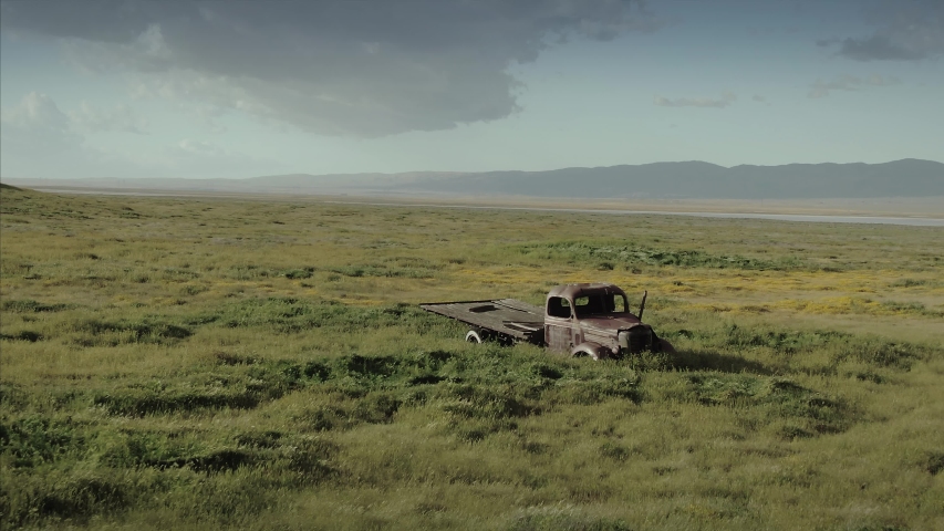 Aerial: abandoned truck and grassland on deserted farm. Carrizo Plain National Monument, California, USA 