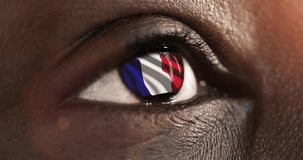 woman blue eye in close up with the flag of France in iris with wind motion. video concept