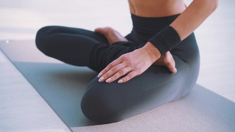 Beautiful sexy slim fit woman sitting in the lotus position twisting in the spine care posture correction medicine yoga asana balance kundalini energy every day routine practice good for woman health 