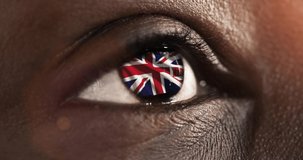 woman blue eye in close up with the flag of United kingdom n in iris with wind motion. video concept