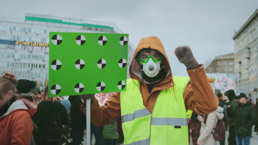 Man hold banner in hand. Tracking points for copy space. Blank green screen board. Human rights. Crowd people day demonstration. Rebel strike protest. Revolution in city street. Political rally 4k.