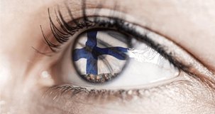 woman green eye in close up with the flag of Finland in iris with wind motion. video concept