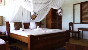 Interior design decor furnishing of luxury show home holiday villa bedroom with four poster bed. Interior design of the tropical villa on sea, island of Zanzibar, Tanzania, Africa, establishing shot - Powered by Shutterstock - Get 15% off with code: PIKWIZARD15