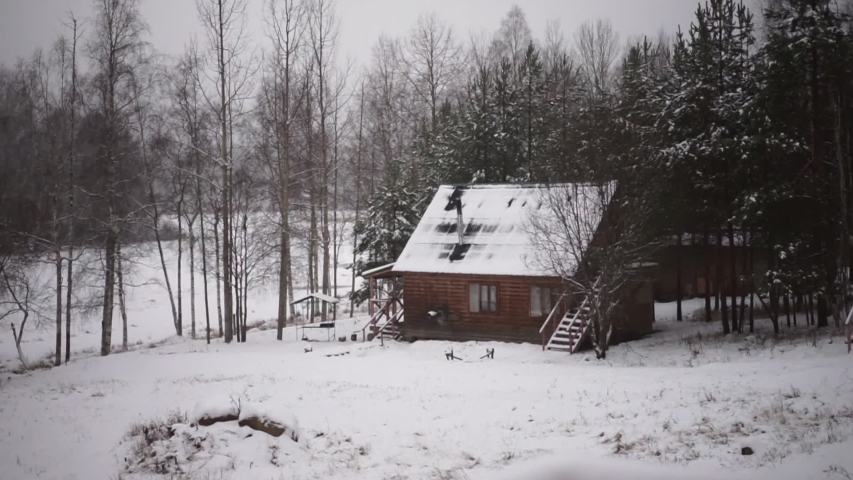 Wooden country house in the snow pine forrest at winter. Cozy cabin between the woods and snowfall, Christmas holidays mood. Russian authentic house in Karelia