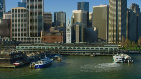 Aerial view of the San Francisco Ferry building with its famous clock tower. Market street and several skyscrapers in the background. Financial District. Shot on Red weapon 8K. California.