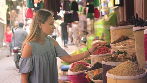 Woman walking on MAROCCAN MARRAKECH spices market. Woman walking on beautiful african arabian spices market and choose spices, travel tourist rose
